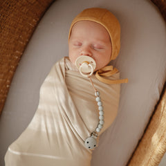 Mushie screwless clasp detail highlights easy, secure pacifier attachment