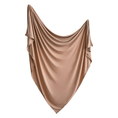 Mushie stretchy swaddle natural flatlay shows soft modal blend and breathable comfort.