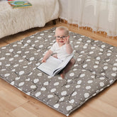 NapCure cloud-pattern play mat laid flat for safe baby playtime