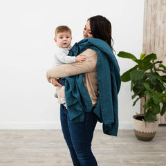 Natemia muslin baby blanket in use as swaddle for newborn snug wrap.