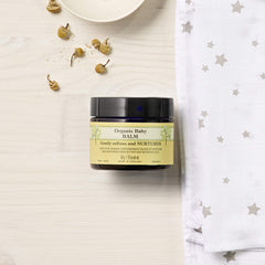 Neal's Yard Remedies Baby Balm application on tiny face demonstrates gentle touch
