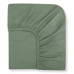 Nora's Nursery muslin crib sheets in sage—soft close-up highlighting breathable organic cotton texture.