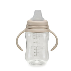 noüka Soft Spout Sippy Cup held by toddler for easy grip and leak-proof drinking