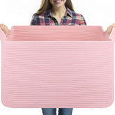OIASKET 95L blanket basket on living room floor storing blankets and pillows for easy access.