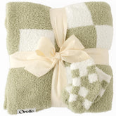 Orelle checkered baby blanket in sage green—soft fabric for cozy crib time.