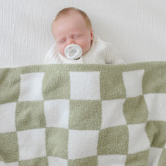 Orelle checkered baby blanket nursery shot—modern sage-green design.