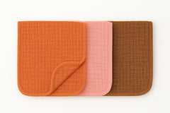 Organic muslin burp cloths 22x10 folded neatly, showcasing generous coverage and soft texture.