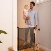 Perma Child Safety retractable gate 55-wide in doorway protects infants and pets.