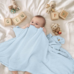 Pinuotu knitted baby blanket blue shown as swaddle for snug daytime naps.