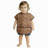 Plie short sleeve bib in brown leopard on child during mealtime for easy cleanup