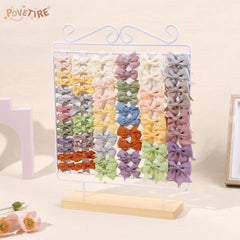 POVETIRE bow organizer featuring white iron stand for quick outfit prep.
