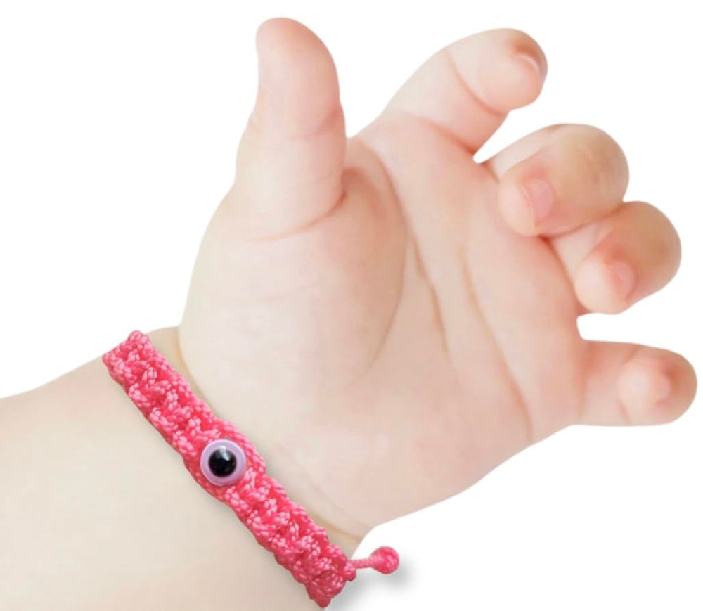 Red baby bracelet with evil eye closeup highlighting the protective charm