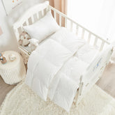 Rose Feather toddler down crib blanket shown in crib with soft warmth