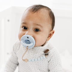 Ryan & Rose Cutie PAT Flat Blue pacifier with clip attachment for mess-free feeding and on-the-go use.