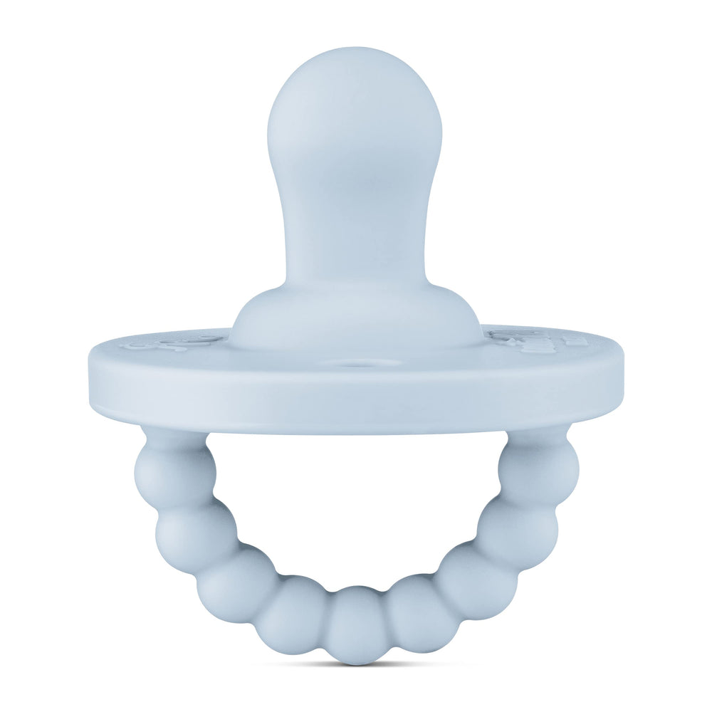 Ryan & Rose Cutie PAT Flat Blue pacifier close-up showing soft silicone nipple for gentle soothing.