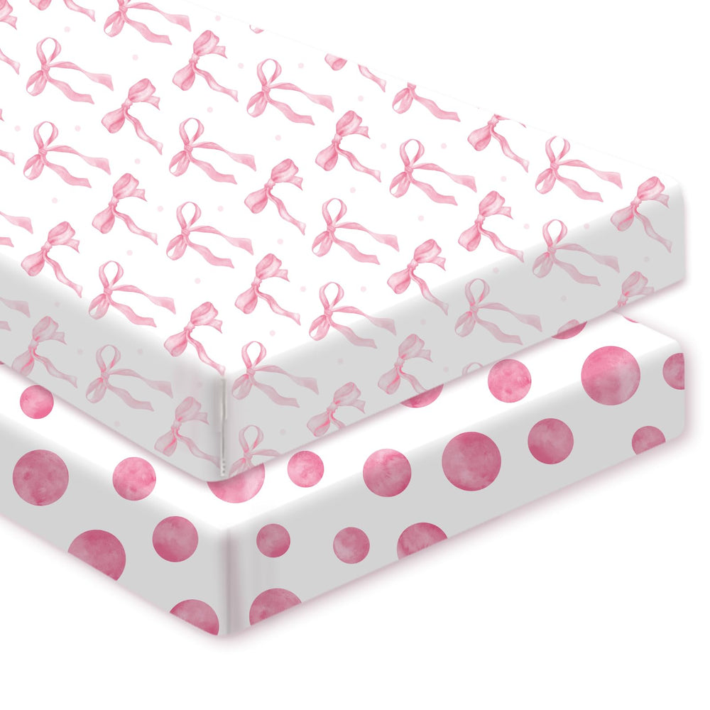 Sel Natural pink bow crib sheet on crib showing secure fit for naps