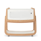 SnuzPod5 bedside bassinet assembly beside bed for easy nighttime access.
