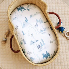 Sorrel + Fern bassinet sheets on a fitted bassinet, showing secure elastic.
