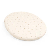 Stokke Sleepi Mini Fitted Sheet V3 folded on bed shows soft, breathable comfort.