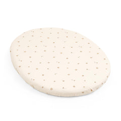 Stokke Sleepi Mini Fitted Sheet V3 folded on bed shows soft, breathable comfort.