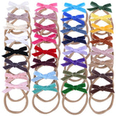 Sugarmelon velvet bow headband on newborn demonstrates soft nylon stretch for comfortable wear.