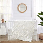 Sweet Jojo Designs off-white crib blanket with macrame trim for cozy nursery decor.