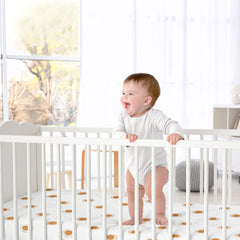 Sweet Jojo Designs orange-white boho sun satin sheet showcased in nursery setting