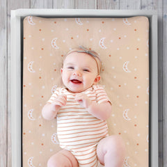 The Peanutshell boho rainbow changing pad cover features buttonhole strap access for secure changes