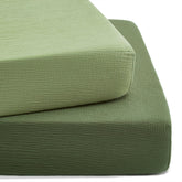 TILLYOU forest-green crib sheet on mattress shows snug fit with cotton softness.
