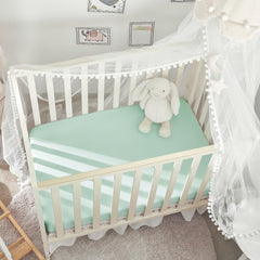 TILLYOU mini crib sheet in light gray, folded, showcasing soft knit texture for cozy naps.