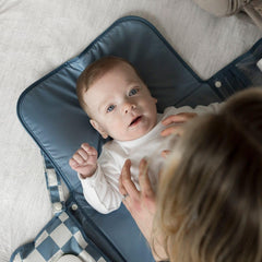 Tiny Twinkle changing pad with stroller clip secures to a stroller for hands-free changes.