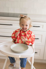 Tiny Twinkle waterproof bib showing full-body coverage during meals.