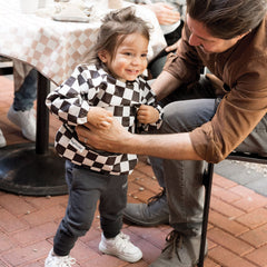 Tiny Twinkle Checkers Black bib side view emphasizing waterproof sleeves for quick cleanup
