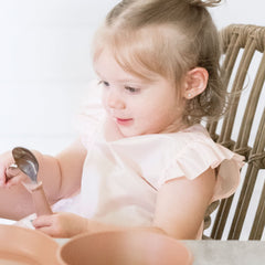 Tiny Twinkle waterproof toddler bib rose closeup shows fast-drying, easy-clean surfaces.