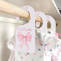 UOAOU Bow Nursery Closet Divider in pink keeps newborn outfits neatly organized.