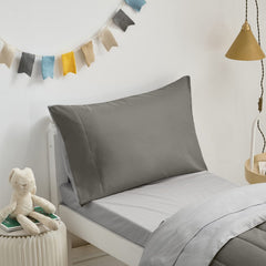 UOZZI BEDDING fitted sheet close-up demonstrates a secure fit for standard toddler beds.