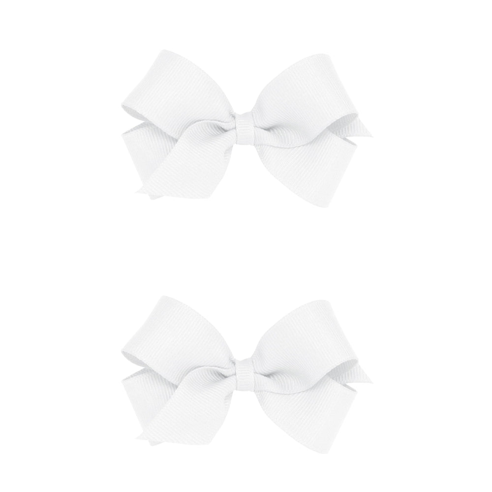 Wee Ones mini white bows on a no-slip clip showing secure hold for active kids