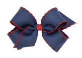 Wee Ones hair bow on navy clip showing moonstitch edge for secure all-day wear