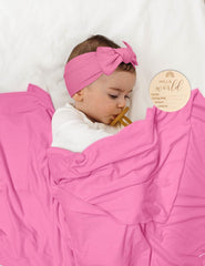 ZURLEFY baby hat in hot pink pairs with swaddle for gentle warmth.