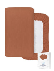 ZURLEFY Rust pack and play sheets folded close-up showing soft muslin cotton for gentle baby skin.