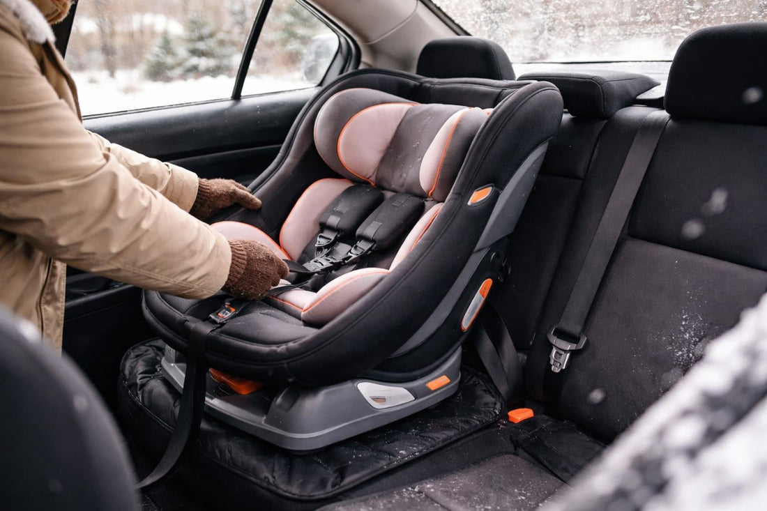 Parent installing car seat in small Ontario sedan