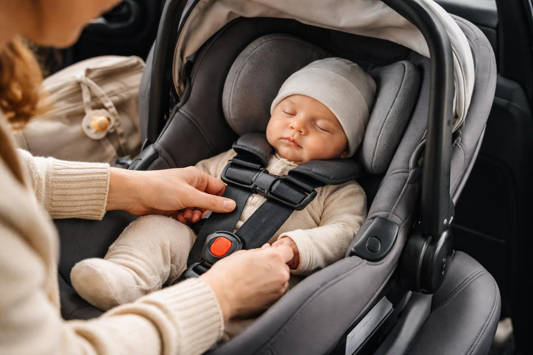 Parent checking infant car seat harness fit in car