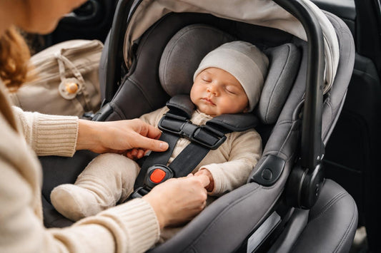 Parent checking infant car seat harness fit in car