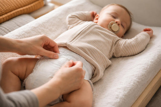 Parent adjusting diaper waistband to prevent overnight leaks
