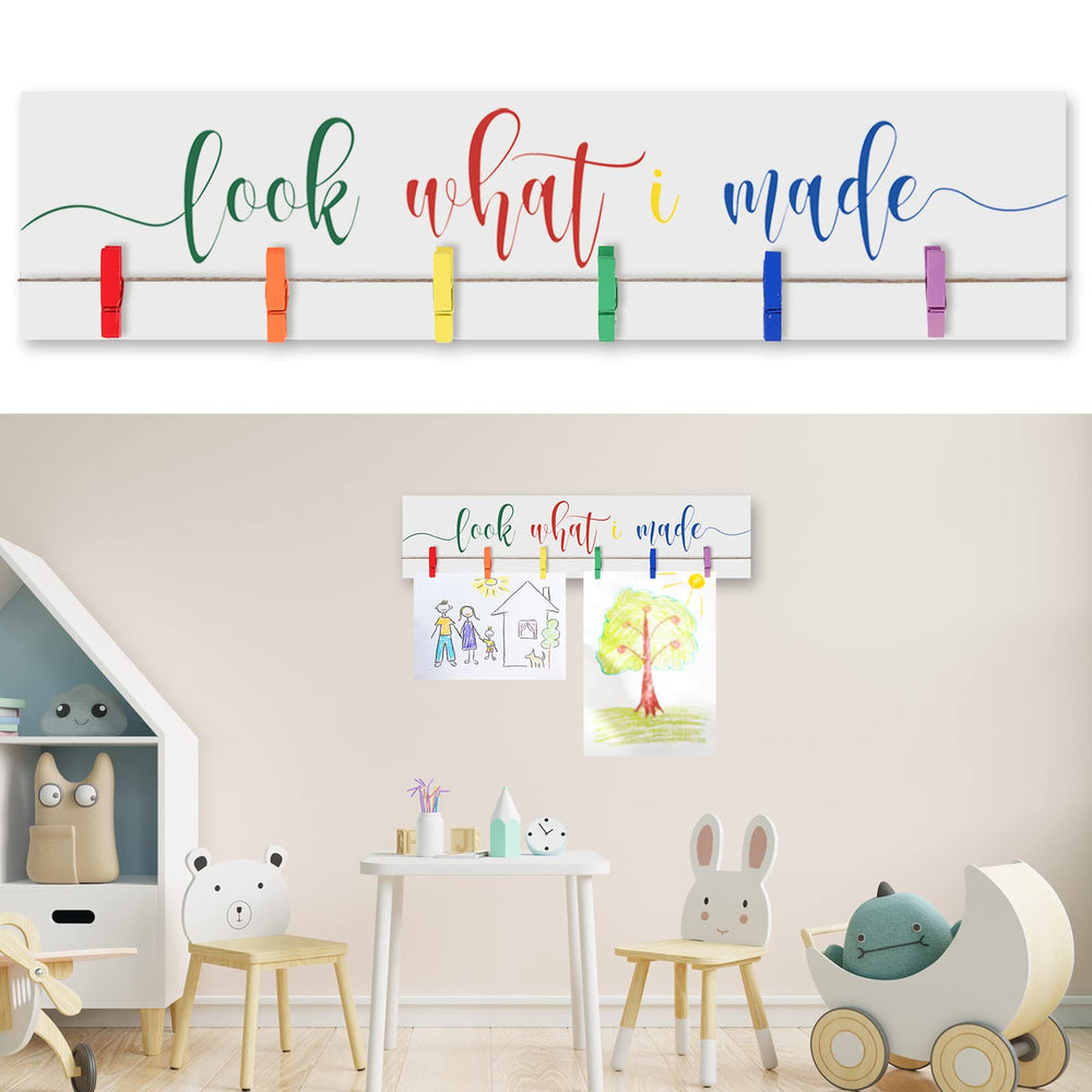 Sawysine Look What I Made sign with clips on a wooden display frame showcasing kids' artwork