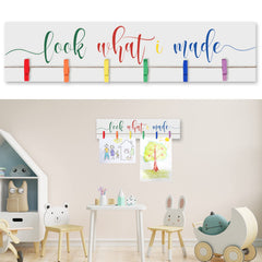 Sawysine Look What I Made sign with clips on a wooden display frame showcasing kids' artwork