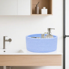 ABenkle small round basket on bathroom vanity holds cotton rounds and remotes