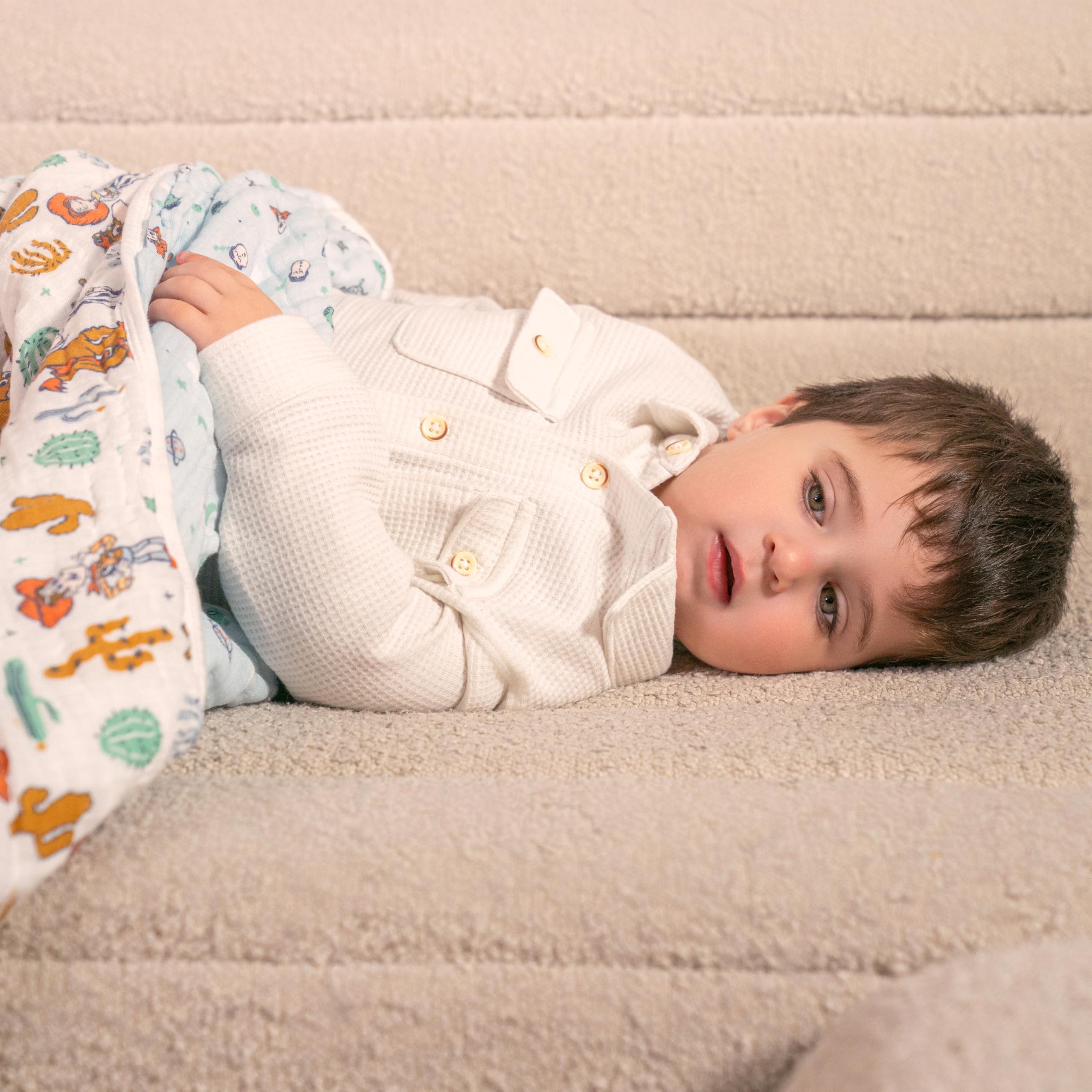 aden + anais 44 inch square muslin blanket on bed for snug sleep