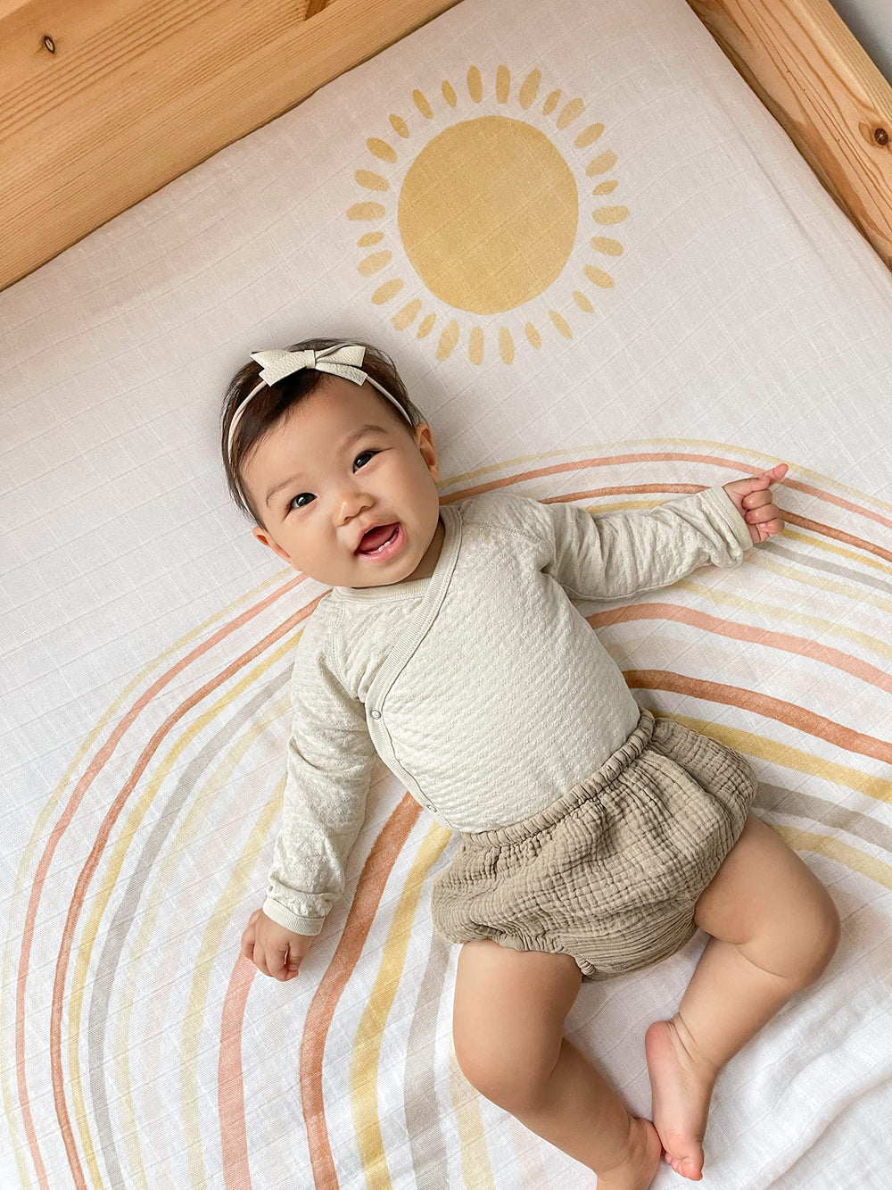 aden + anais swaddle being used as a stroller cover in sunny day setting.