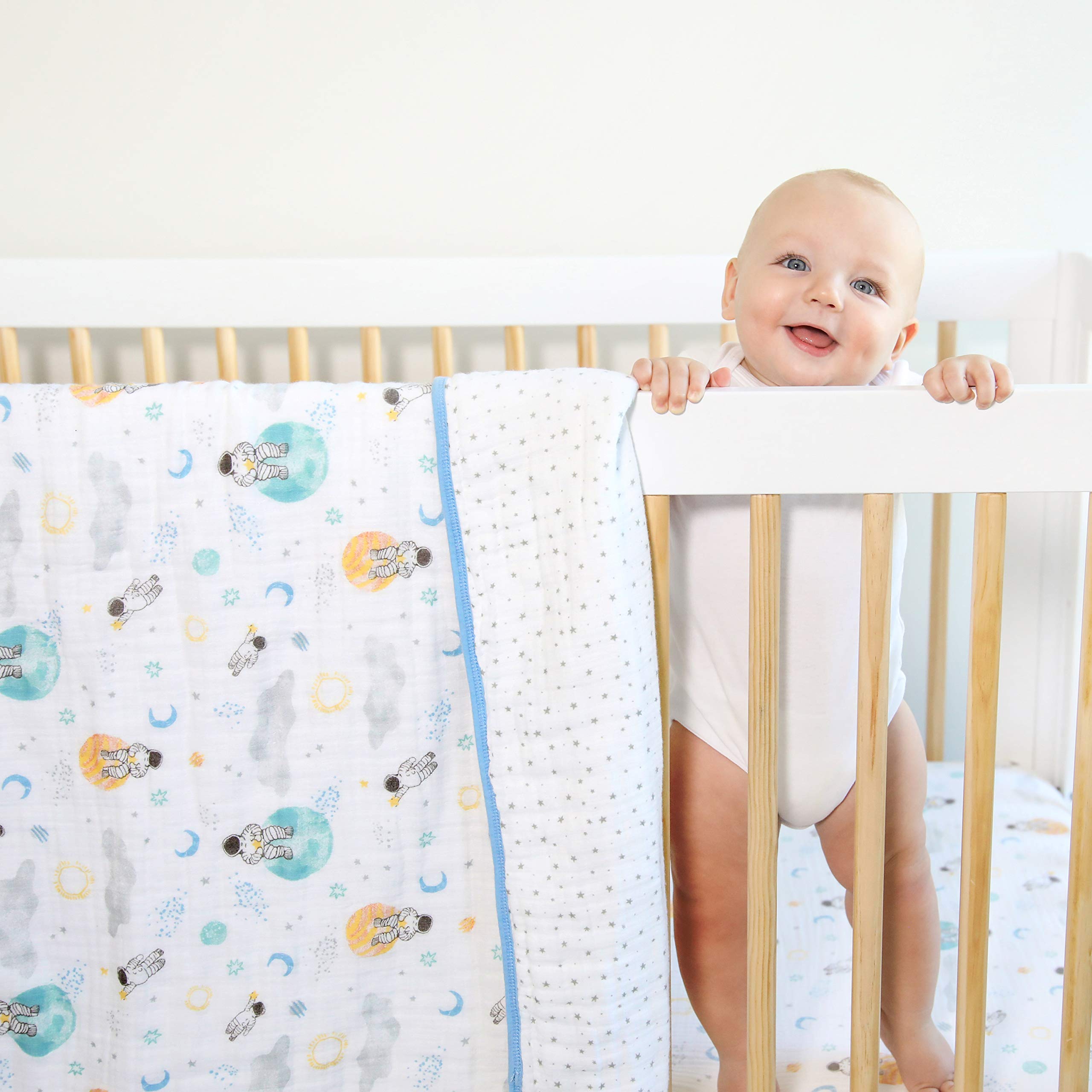 aden + anaïs Essentials Dream Blanket under a baby resting with space explorers print for soft warmth.